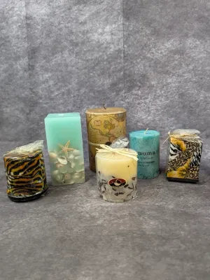Collection of decorative pillar candles featuring animal print, sea glass, map design, and embedded seashell accents.
