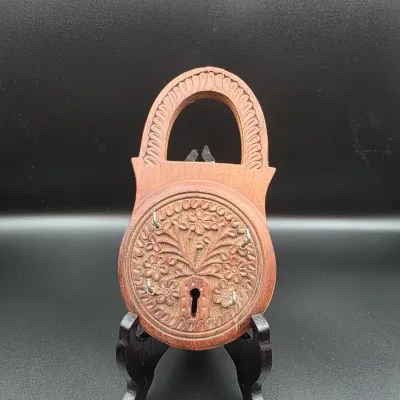 Hand-carved wooden padlock-shaped key holder featuring detailed floral motifs, keyhole accent, and small metal hooks.