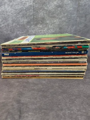 Stack of vintage vinyl LP records featuring artists such as Lawrence Welk, Uriah Heep, and Judy Collins, showing moderate shelf wear on...