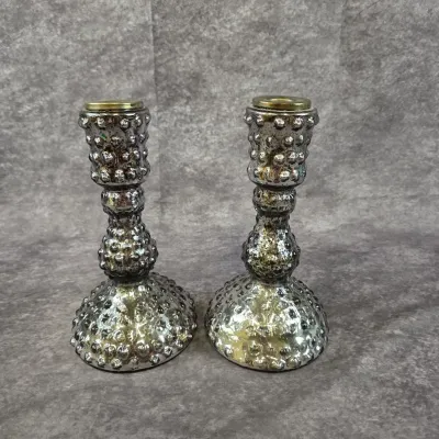 Pair of vintage mercury glass candlesticks featuring a hobnail texture and brass-toned metal inserts.