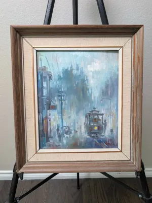 Framed oil painting by Albert Tolf depicting a San Francisco street scene with a cable car in a misty, impressionistic style, housed in a...