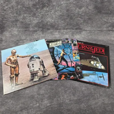 Three vintage Star Wars vinyl record albums, including "The Story of Star Wars," "The Empire Strikes Back," and...