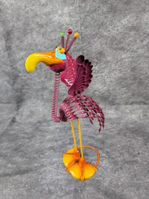 Whimsical metal bird garden sculpture featuring a coiled spring neck, vibrant pink and yellow painted finish, and beaded crest details.