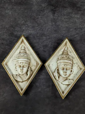 Pair of mid-century modern diamond-shaped chalkware wall plaques featuring relief-sculpted Thai dancers in cream and gold finish.