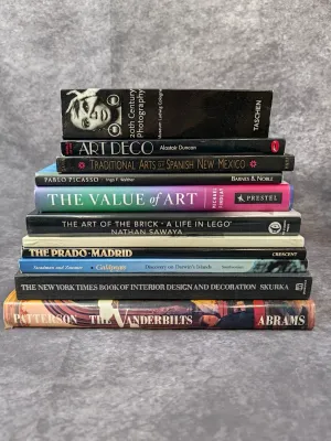 Stack of ten art, design, and history books, including titles on Art Deco, Pablo Picasso, and the Vanderbilts.