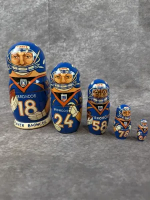 Set of five hand-painted Denver Broncos wooden nesting dolls featuring team players in blue jerseys.