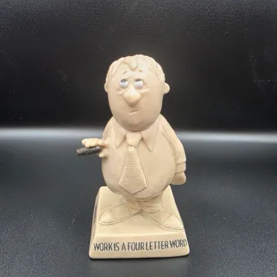 Vintage Paula Company novelty resin figurine depicting a businessman holding a cigar, with the inscription 'Work is a Four Letter...