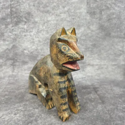 Hand-carved and painted wooden folk art animal figurine, depicting a striped cat or canine with an open mouth, showing some surface wear...