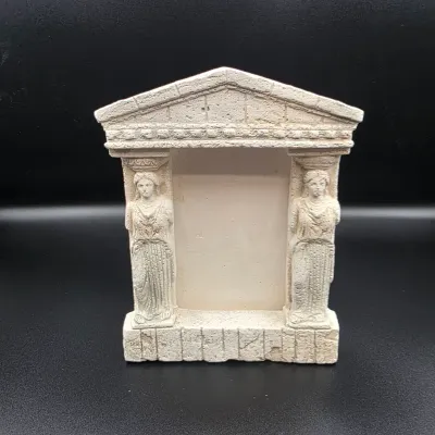 Neoclassical style faux-stone photo frame shaped like a Greek temple facade with caryatid column supports.