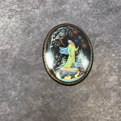 Russian Palekh style hand-painted lacquer box lid featuring a detailed winter fairy tale scene with gold filigree border.