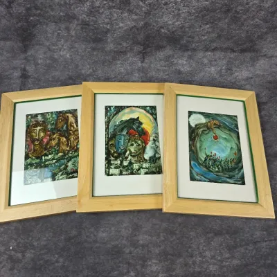 Trio of framed surrealist art prints in light wood frames, featuring dreamlike imagery with faces, horses, and celestial motifs.