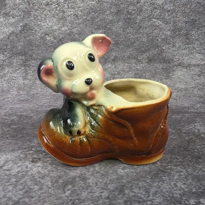 Vintage ceramic puppy in a boot planter with glossy airbrushed details, circa mid-20th century.