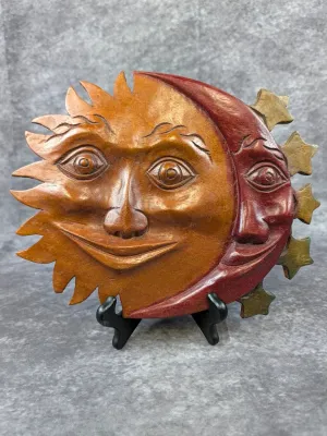Hand-carved wooden celestial plaque featuring a smiling sun and crescent moon face, finished in warm brown and reddish tones.
