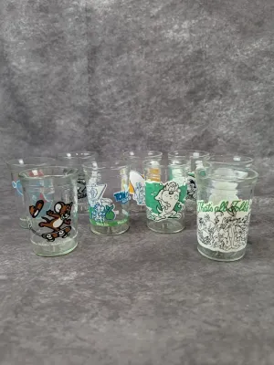 Collection of vintage Welch's jelly glasses featuring Looney Tunes and Tom and Jerry characters, circa 1990s.
