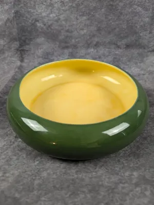 Mid-century modern ceramic bowl featuring a glossy forest green exterior and a contrasting yellow interior. Red Wing