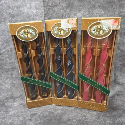Three boxed pairs of Beeswax Designs 12-inch spiral taper candles, featuring decorative hand-painted details in dark brown, navy blue,...