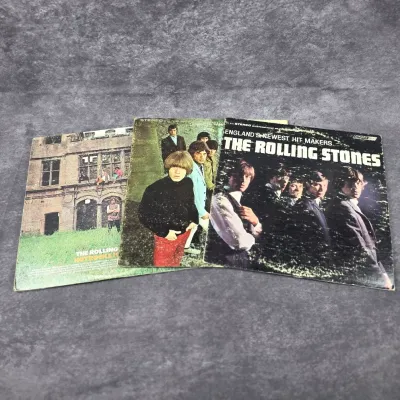 Three vintage vinyl record albums by The Rolling Stones, including "England's Newest Hit Makers" and "Hot Rocks...