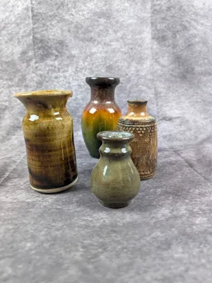 Collection of four vintage studio pottery miniature vases featuring earthy glazes and unique textures.