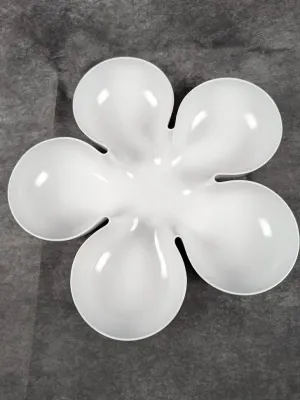 White flower-shaped divided serving dish or painter's palette tray made of smooth plastic or melamine.