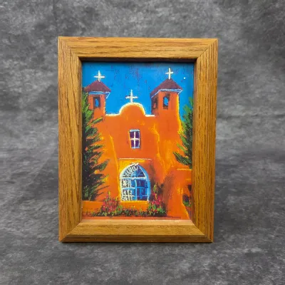 Small framed pastel or chalk drawing depicting a Southwestern adobe church, housed in a simple oak frame.