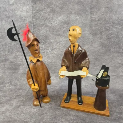 Two vintage mid-century modern hand-carved wooden figurines, including a guard with a halberd and a businessman reading a ticker tape,...