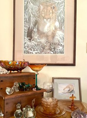 Assorted vintage glassware and framed art, featuring a large framed print of a cougar in winter, amber carnival glass bowls, and small...