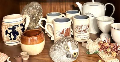 Assorted vintage ceramics and collectibles, including Welsh castle souvenir mugs, a German-style beer stein, a white teapot, and a...