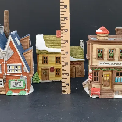 LOT 135: Department 56 New England Village Series Yankee Jud Bell Casting, Livery Stable & Boot Shop and Ben's Barber Shop