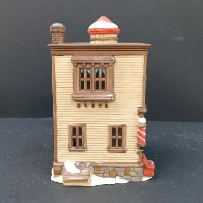 LOT 135: Department 56 New England Village Series Yankee Jud Bell Casting, Livery Stable & Boot Shop and Ben's Barber Shop