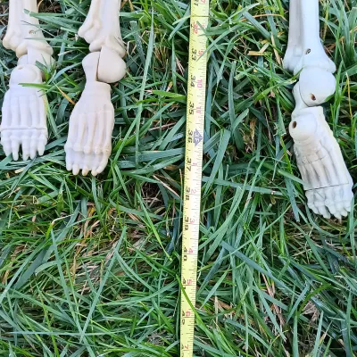 LOT 109: Inflatable 6ft Grave Stones, Light-Up Owl Pumpkin and Plastic Skeletons