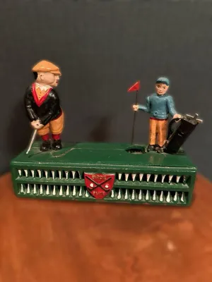 Vintage cast iron "Birdie Putt" mechanical bank featuring a golfer and caddy on a green base, showing some paint wear...