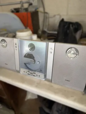 Vintage Philips silver micro shelf system featuring a vertical-loading CD player and matching stereo speakers, circa early 2000s.