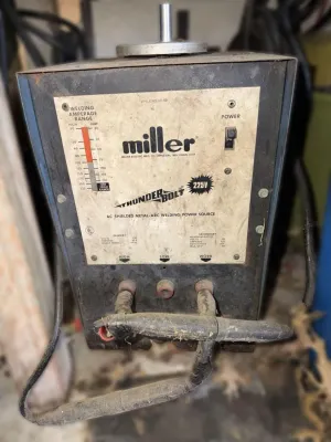 Vintage Miller Thunderbolt 225V AC shielded metal-arc welding power source, showing some wear and dust from age and use.