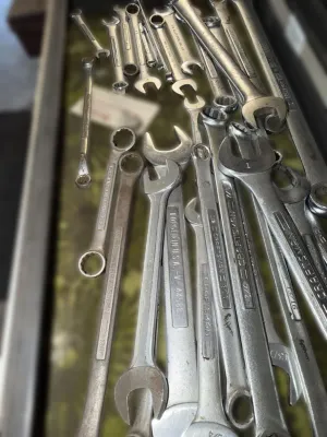 Assortment of vintage Craftsman and other brand combination and open-end wrenches in various sizes, showing signs of use.