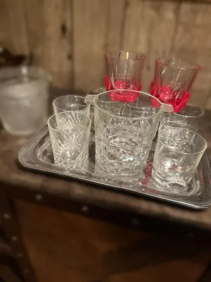 Assorted barware set on a silver-tone tray, including cut-glass tumblers, a small ice bucket, and two Maker's Mark glasses with...