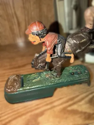 Vintage cast iron "Bucking Mule" mechanical bank, featuring a jockey figure on a bucking mule, with some paint wear consistent...