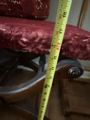 Vintage wooden glider rocker with red patterned upholstery, shown with a measuring tape indicating a seat height of approximately 16 inches.