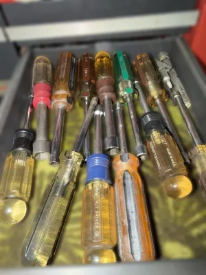 Assorted vintage Craftsman nut drivers and screwdrivers with color-coded acetate handles, showing signs of use.