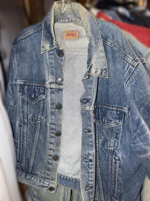 Vintage Levi's denim trucker jacket with a medium wash, featuring classic button-front closure and chest pockets.