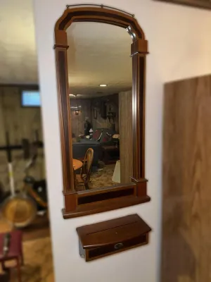 Vintage wood-framed wall mirror with a matching wall-mounted shelf, featuring a classic arched top and dark wood inlay details.