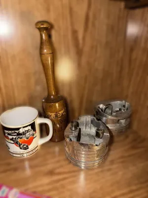 Vintage Don Garlits "Big Daddy" Swamp Rat XXX and Hauler mug, shown alongside a wooden mallet and two metal engine pistons.