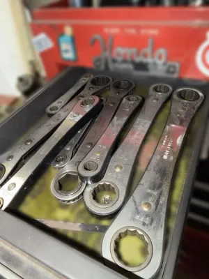 Assortment of vintage Craftsman ratcheting box wrenches showing signs of use and wear, organized in a toolbox drawer.