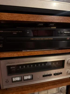Vintage Accuphase T-101 FM stereo tuner paired with a Denon DCM-370 5-disc CD changer, both housed in a wooden media console.