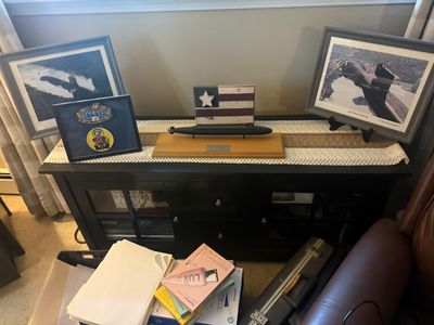 Collection of military submarine memorabilia, including framed aerial photographs, a model submarine on a wooden base, and framed...