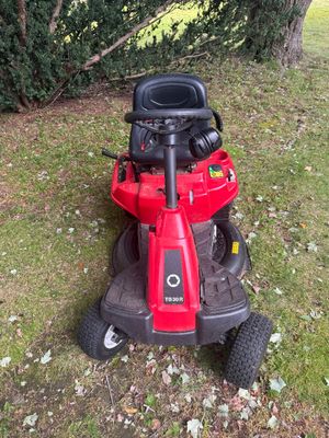 Troy-Bilt TB30R rear engine riding lawn mower in red and black, showing some wear from outdoor use.
