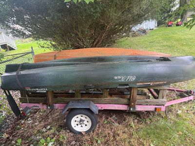 Old Town Topwater PDL kayak in dark green, shown loaded on a pink utility trailer with an orange kayak behind it.