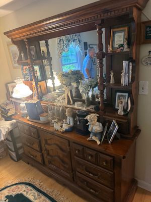 Vintage wooden hutch with a mirrored back, turned support columns, and built-in shelving, featuring a lower buffet cabinet with drawers...