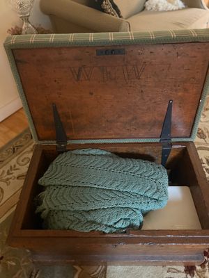 Vintage wooden storage chest with an upholstered green plaid lid, featuring the initials 'WTW' carved on the inside lid.