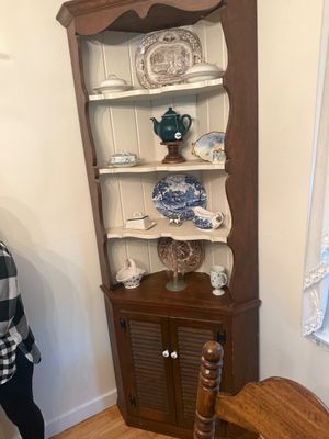 Vintage early American style pine corner hutch with a dark stained exterior, painted cream interior shelves, and lower louvered cabinet...