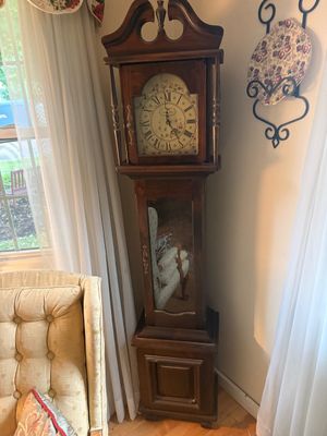Vintage Tempus Fugit grandfather clock featuring a dark wood case with a broken arch pediment and a floral-accented dial.